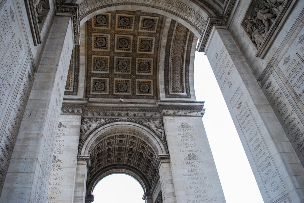 a very tall arch with a clock on it's side