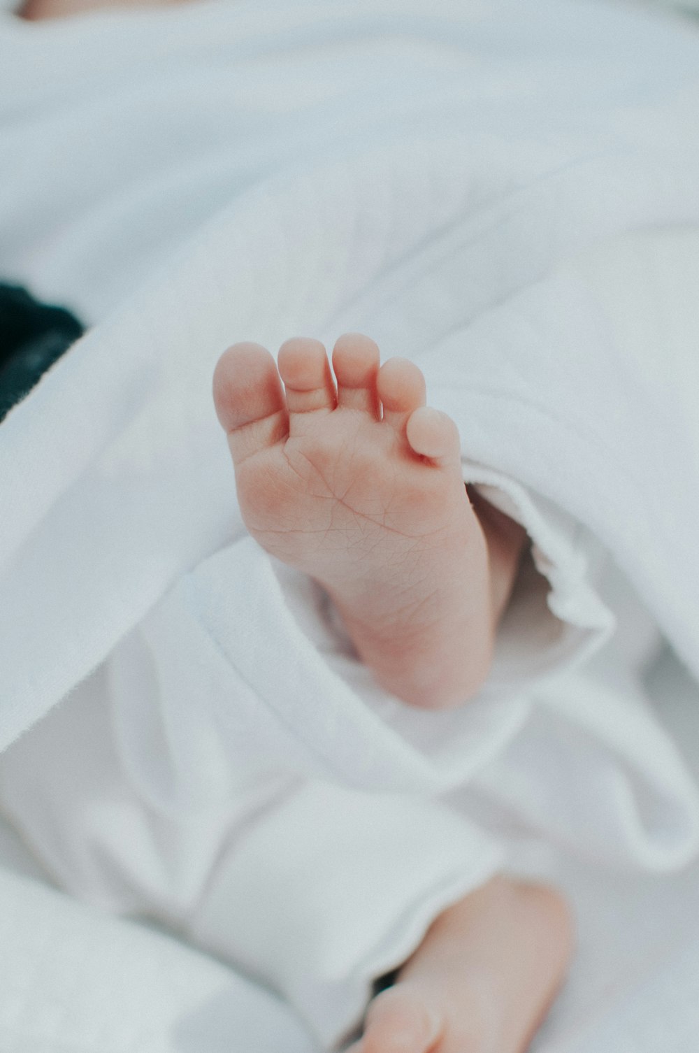 a close up of a baby's foot under a blanket