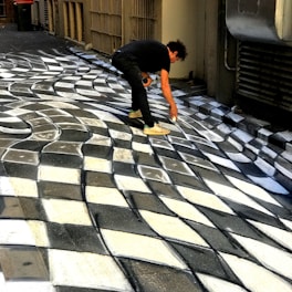 Visitors interacting with a large 3D optical illusion painting that makes them appear to float.