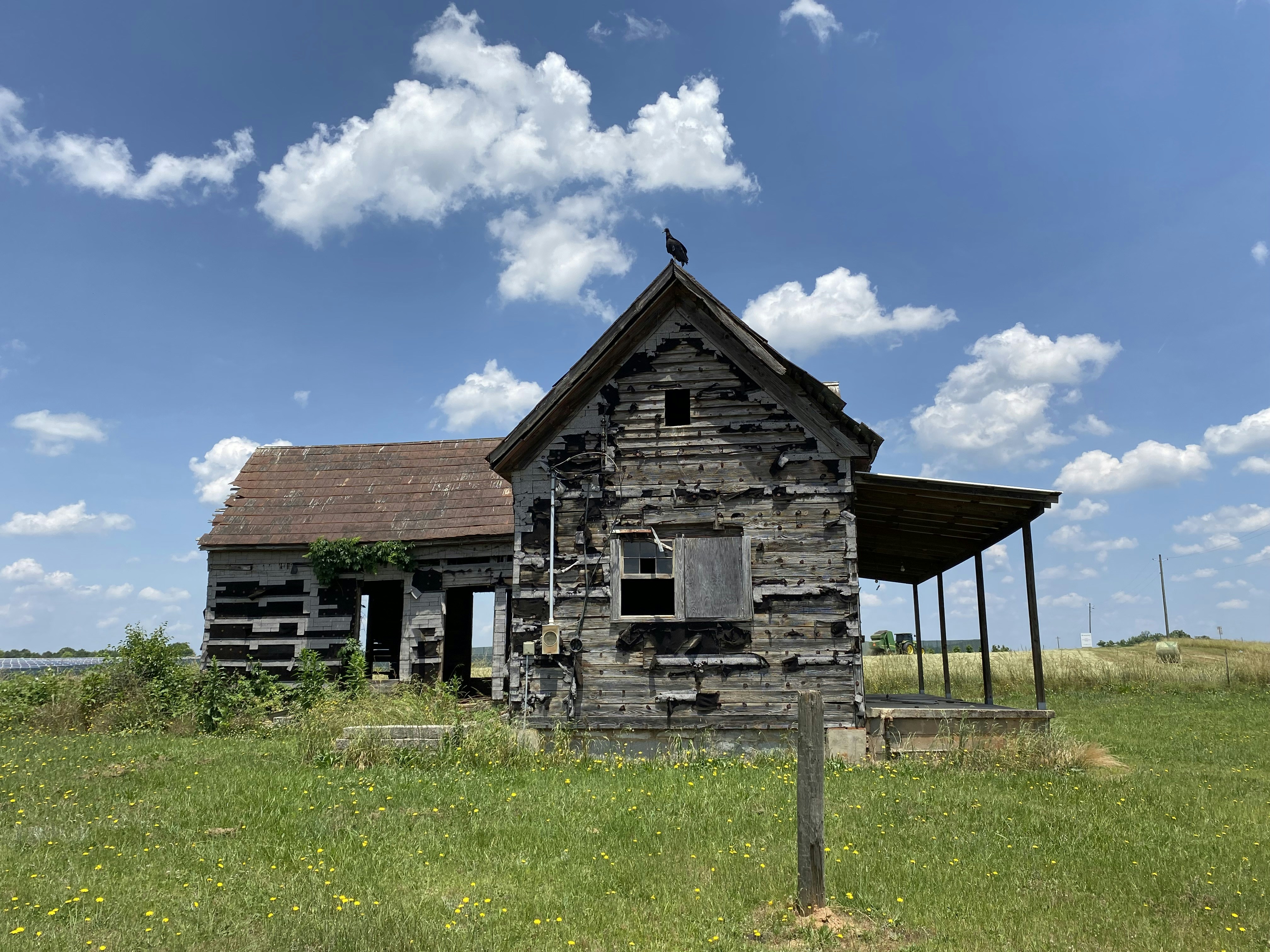 an old wooden building sitting in a field