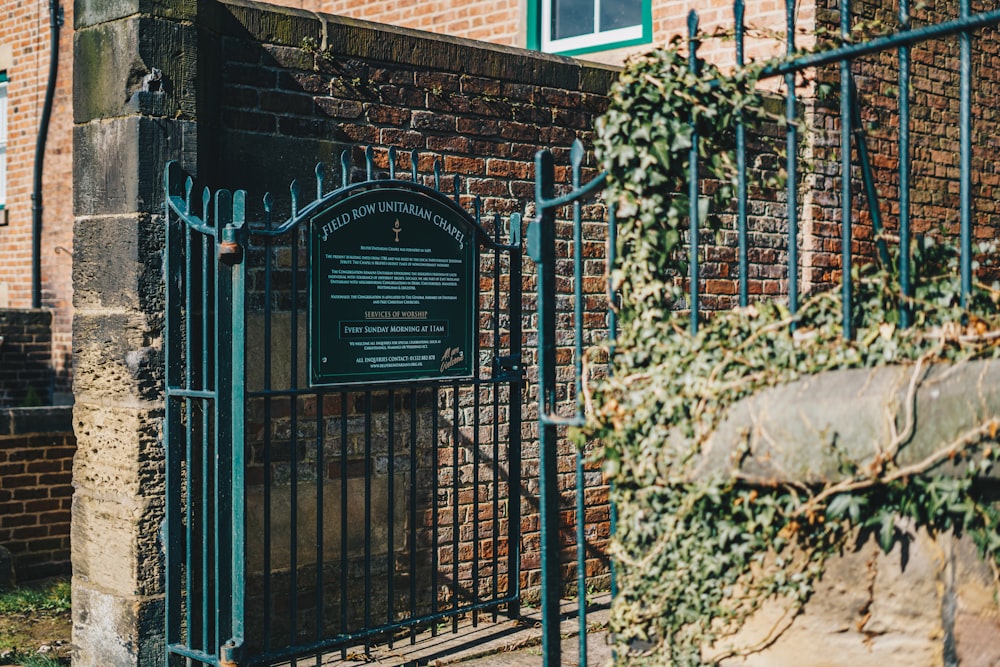 a brick building with a gate and a sign on it