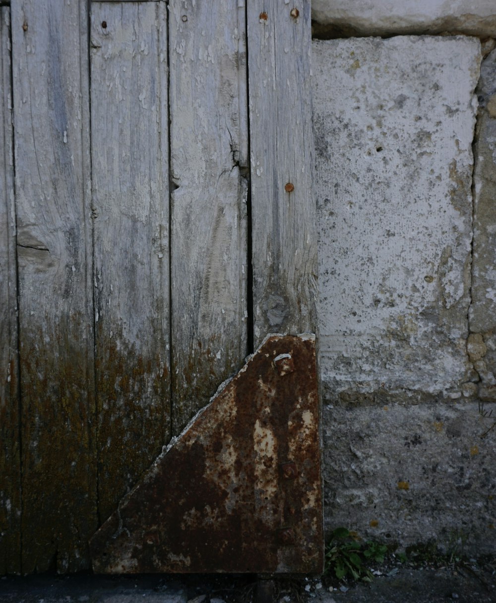 uma porta de madeira velha com um puxador de metal enferrujado