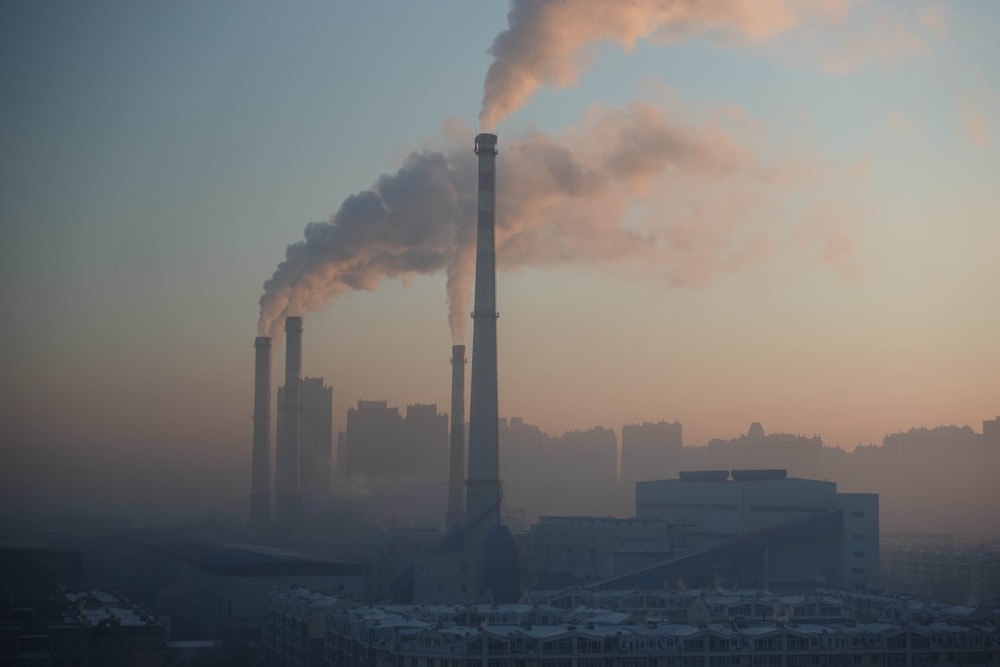 a smokestack emits from a factory in a city