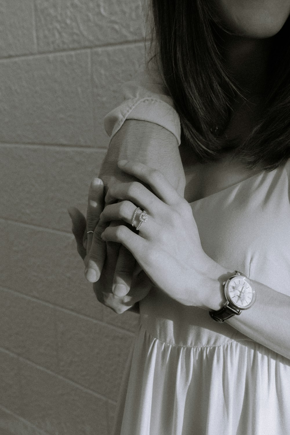 a black and white photo of a woman holding a watch