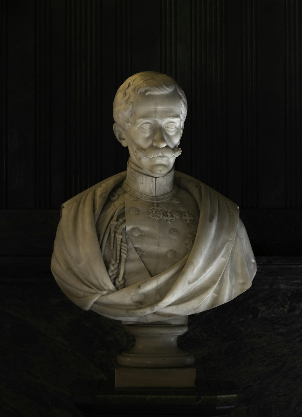 a marble bust of a man with a scarf around his neck