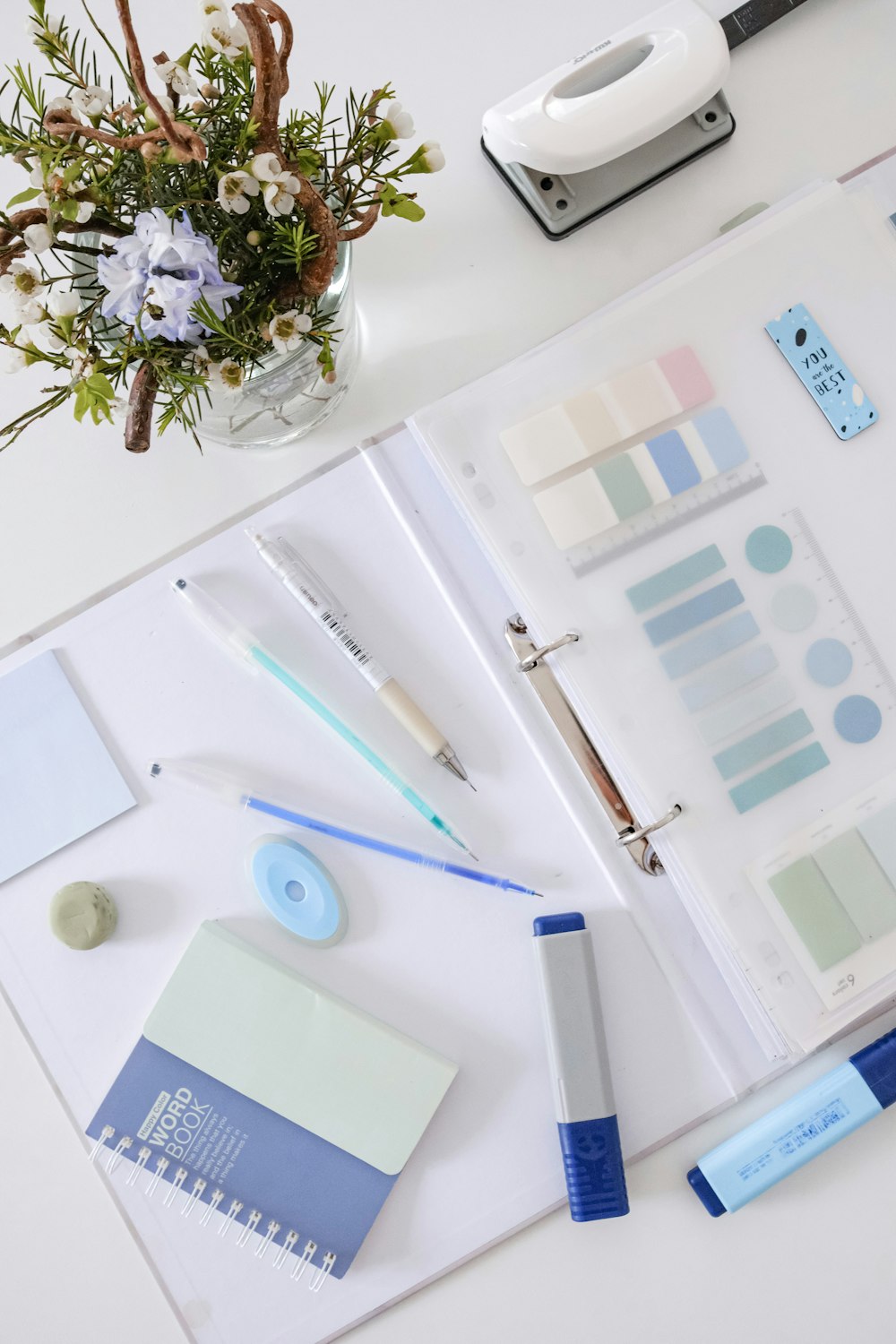 a white table topped with lots of office supplies