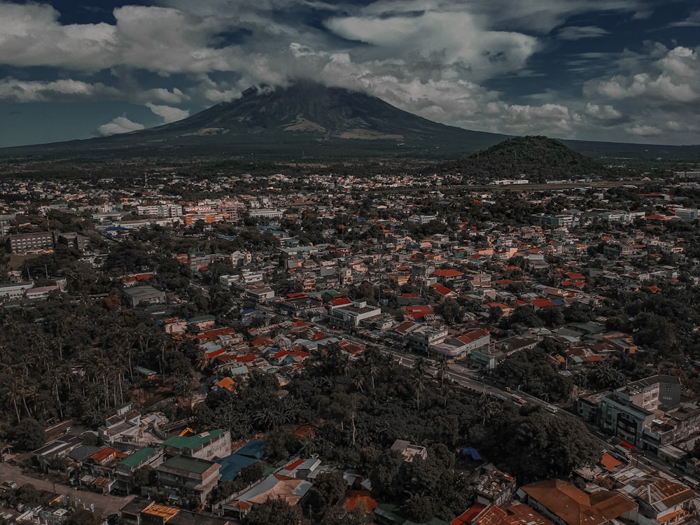 an aerial view of a city with a mountain in the background