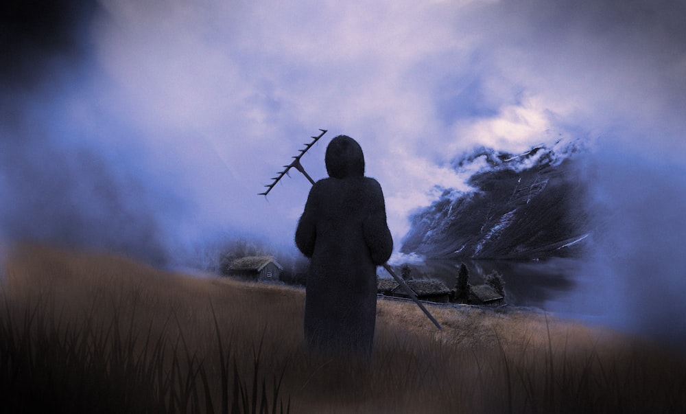 una persona in piedi in un campo con un bastone in mano