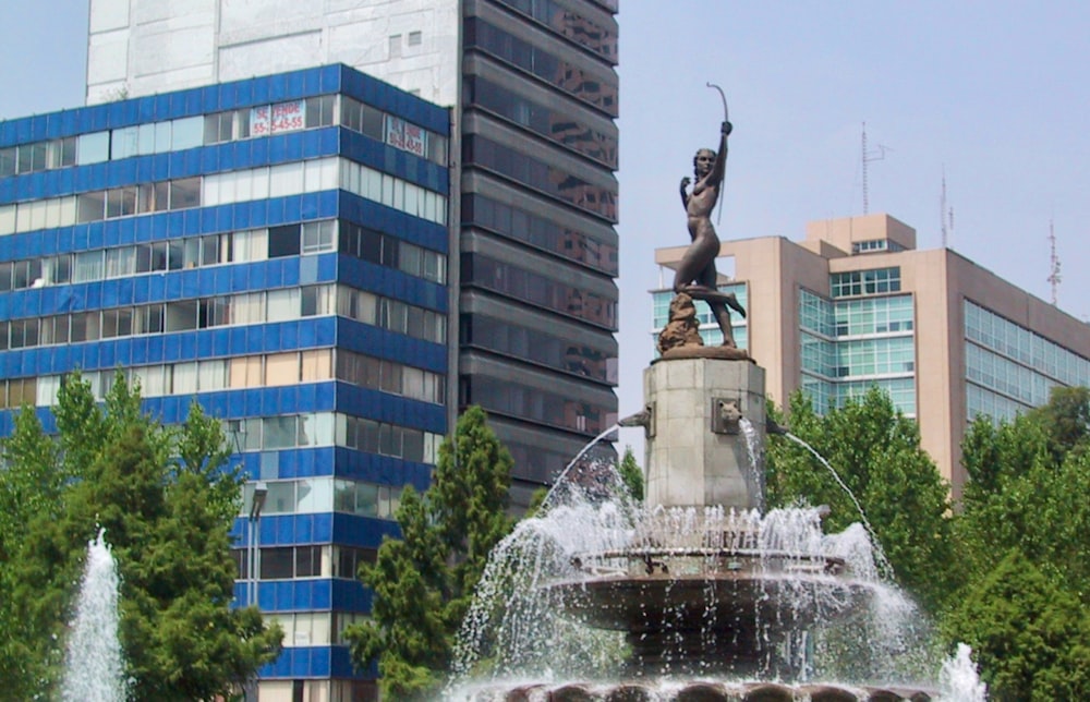 a fountain with a statue of a man holding a bow