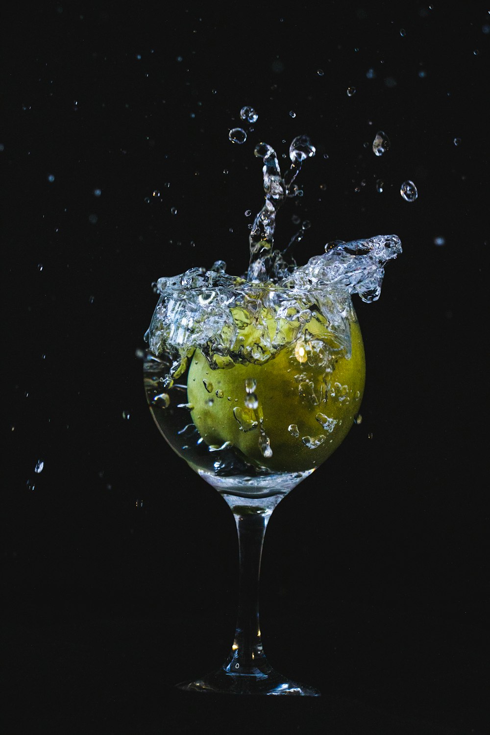 a glass filled with water and an apple