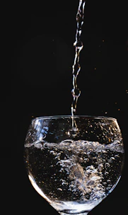 Close-up of crystal-clear water pouring from a modern filtration system into a glass.