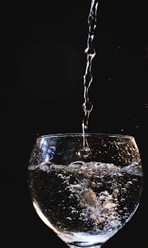 Close-up of clear mineral water pouring into a glass.