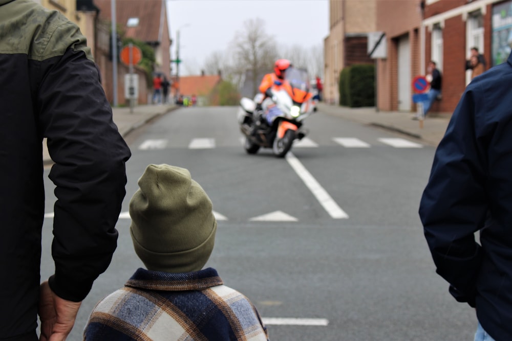 a man standing next to a little boy on a street