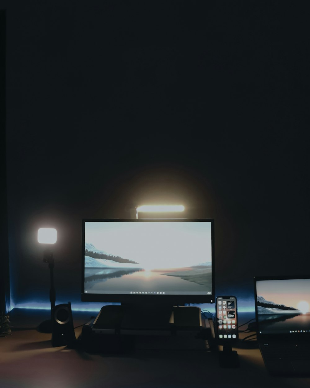 a desk with two monitors and a cell phone