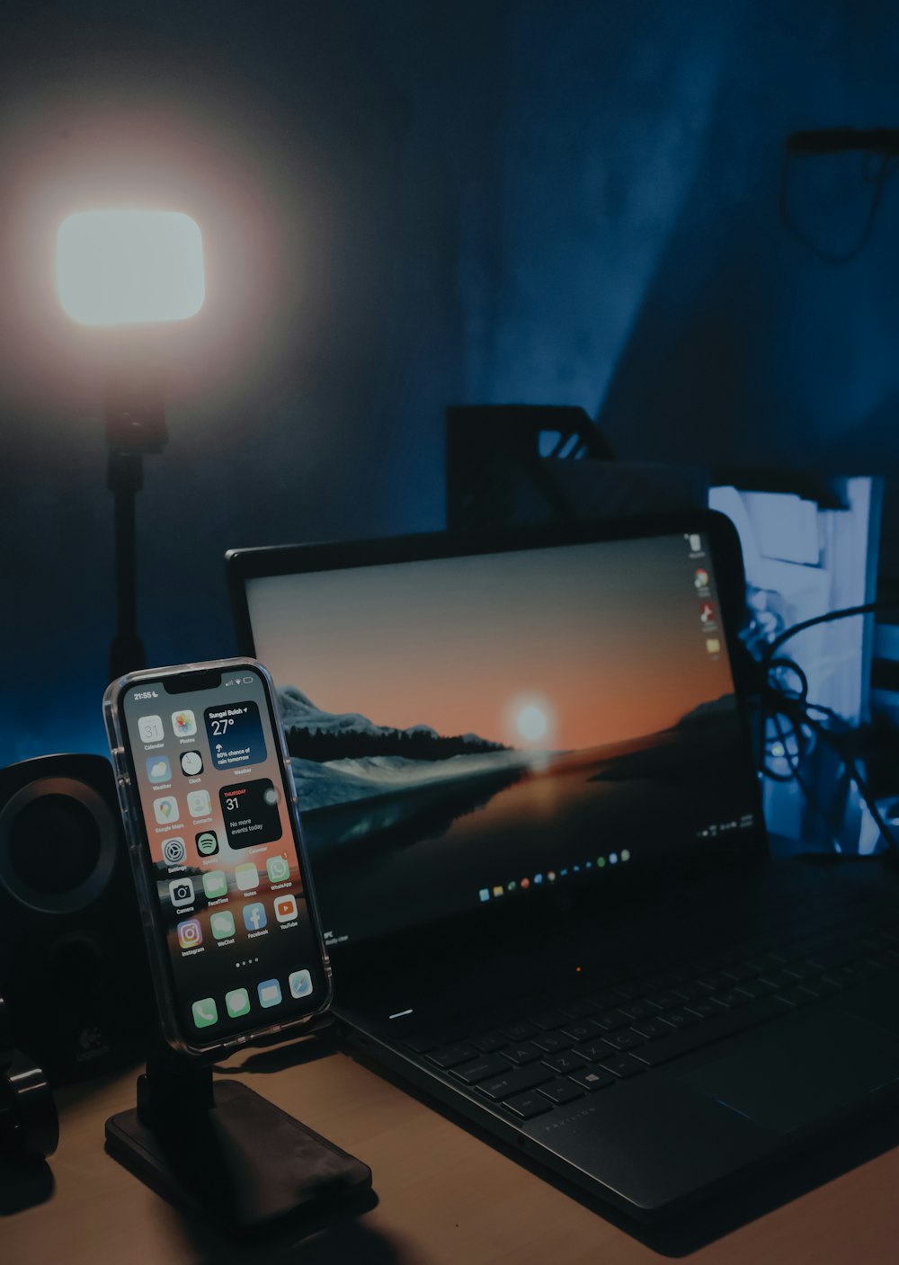 a cell phone sitting on top of a desk next to a laptop