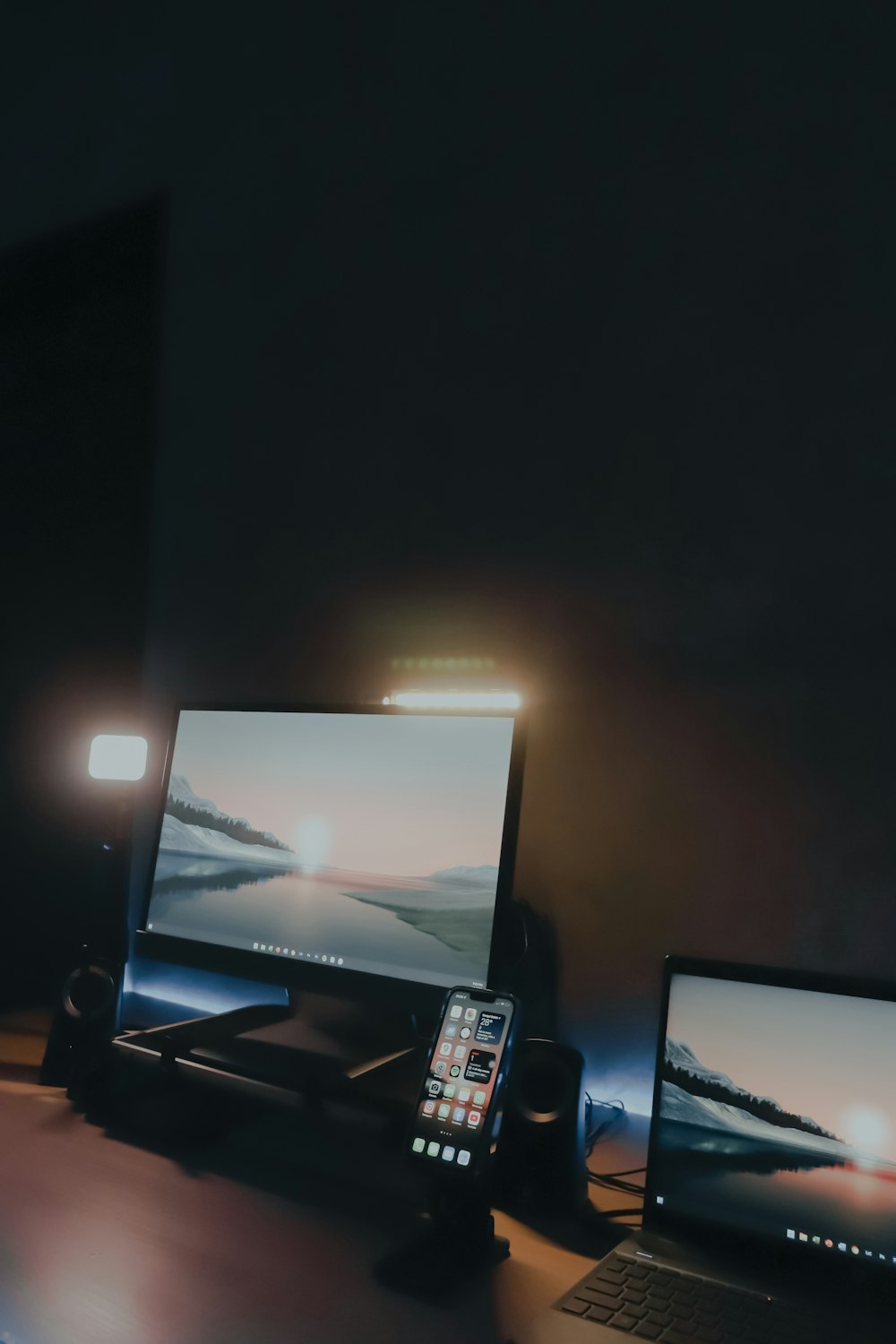 a desk with two laptops and a phone on it