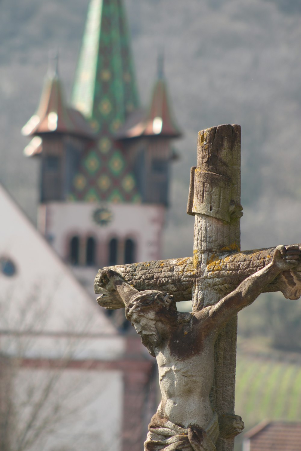 a wooden cross with a building in the background