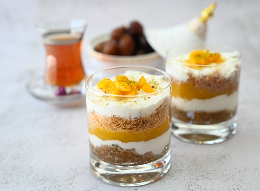 a couple of glasses filled with food on top of a table