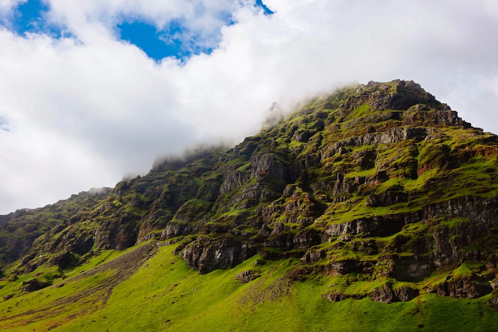 a very tall mountain covered in green grass