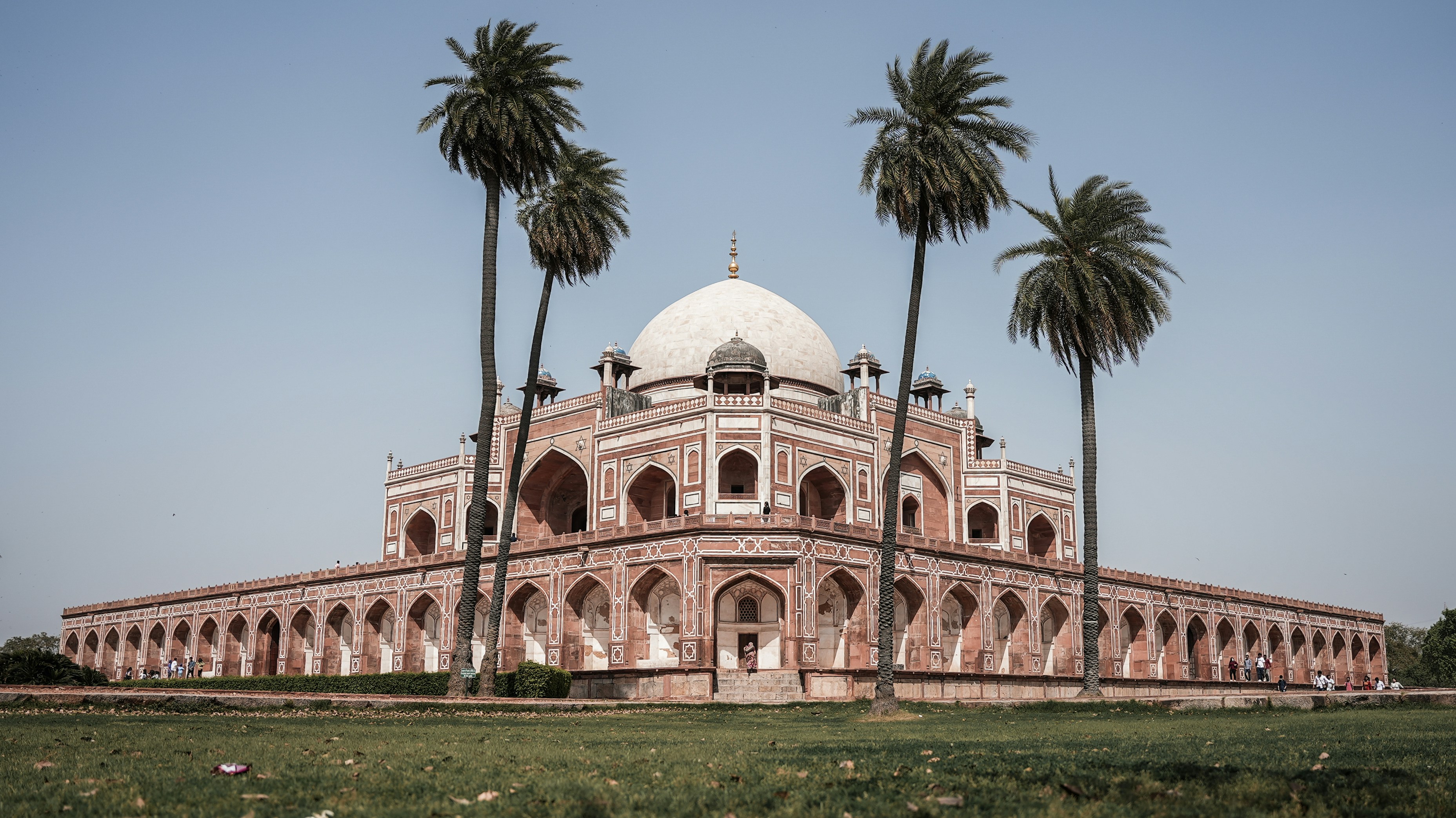 a large building with a dome surrounded by palm trees