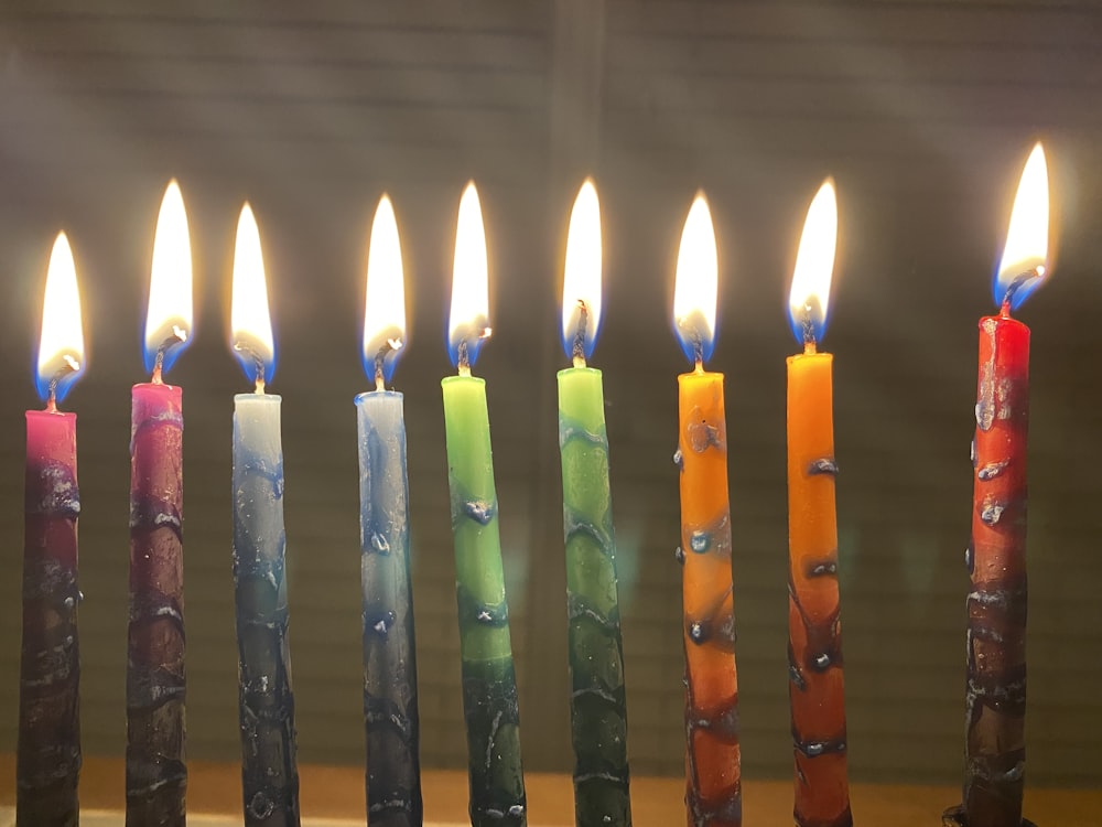 a row of lit candles sitting on top of a table