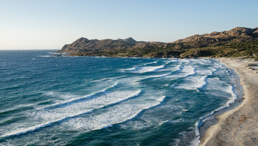 a view of a beach with waves coming in from the ocean