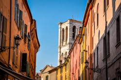 a narrow street with buildings and a clock tower in the background