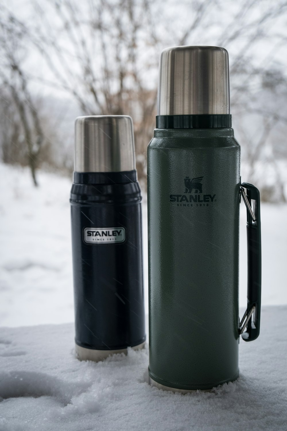 a couple of water bottles sitting on top of a snow covered ground