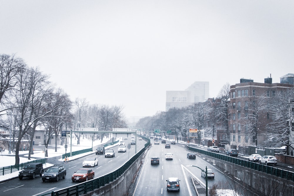 a city street filled with lots of traffic covered in snow