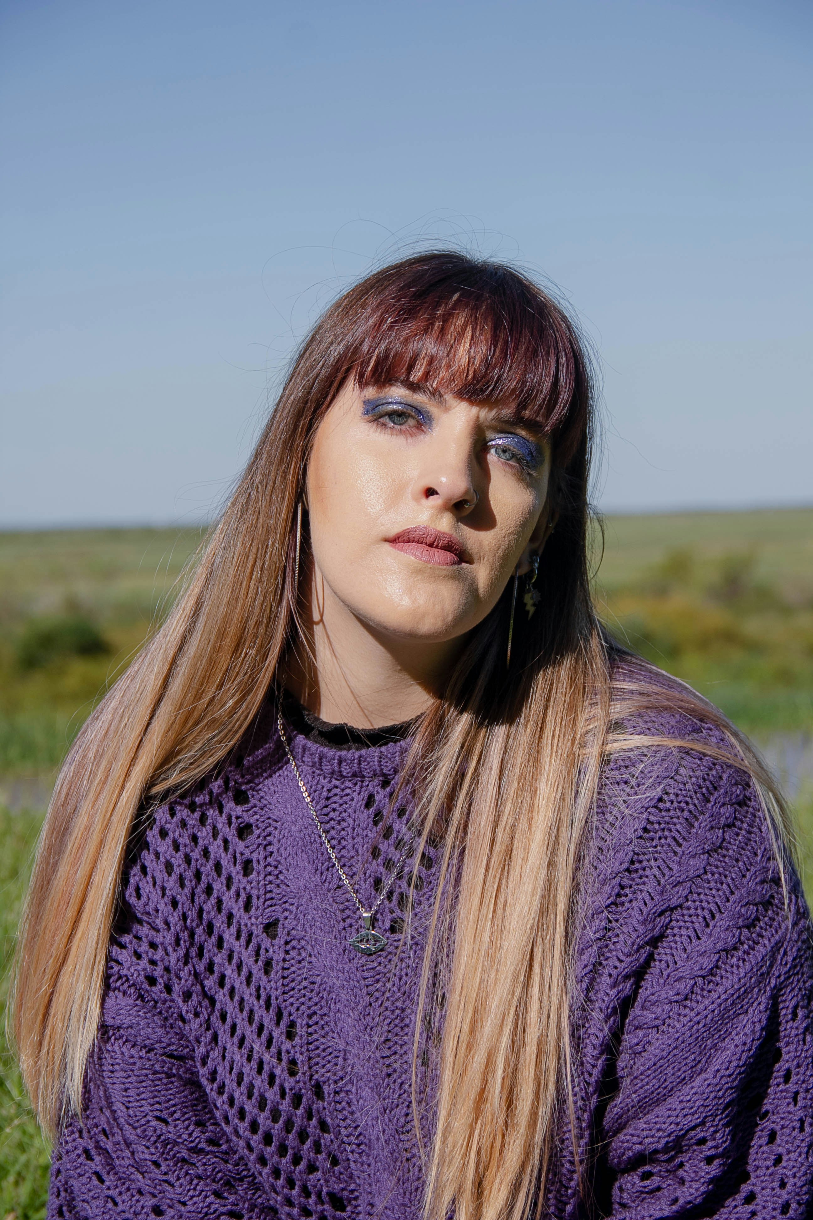 a woman with long hair wearing a purple sweater