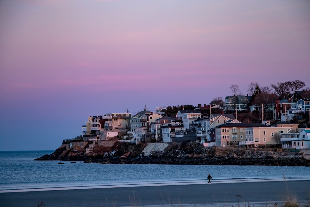 a person walking on a beach next to the ocean