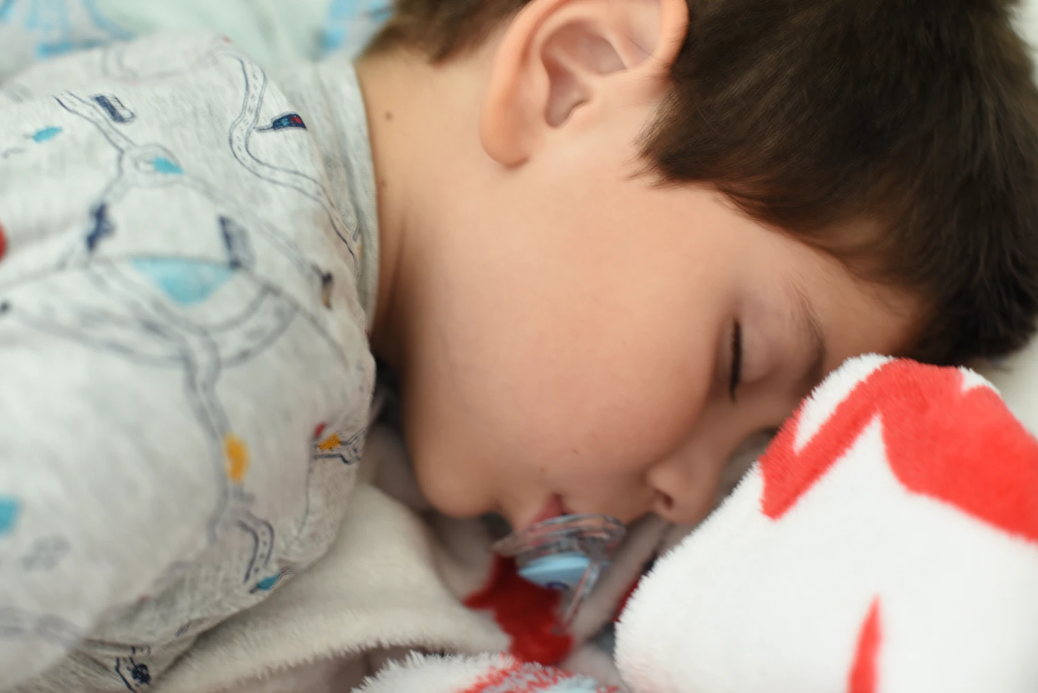 A young child resting quietly with a stuffed animal, working through a big feeling