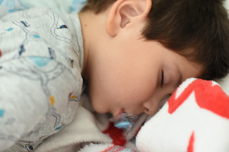A calm child resting quietly with a stuffed animal after settling down