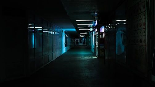 A dark corridor lined with concealed panels emitting faint blue light.