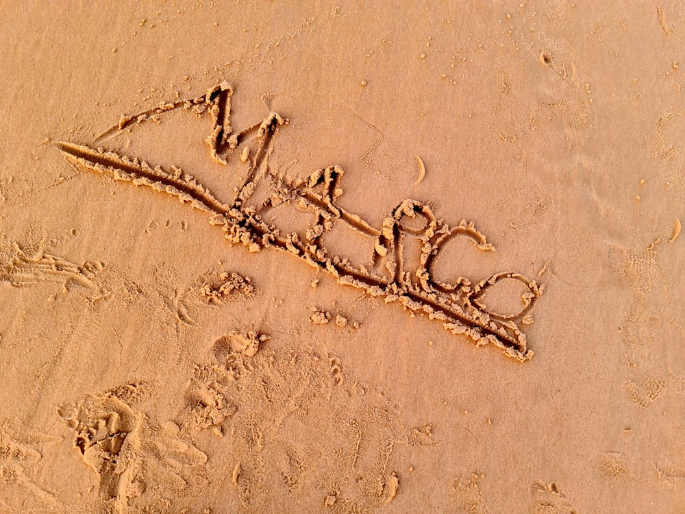 a word written in the sand on a beach