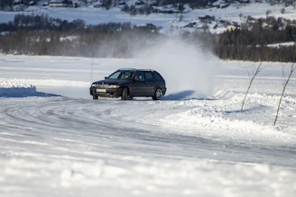 A confident student driver practicing on a safe, snowy driving track in Gothenburg.