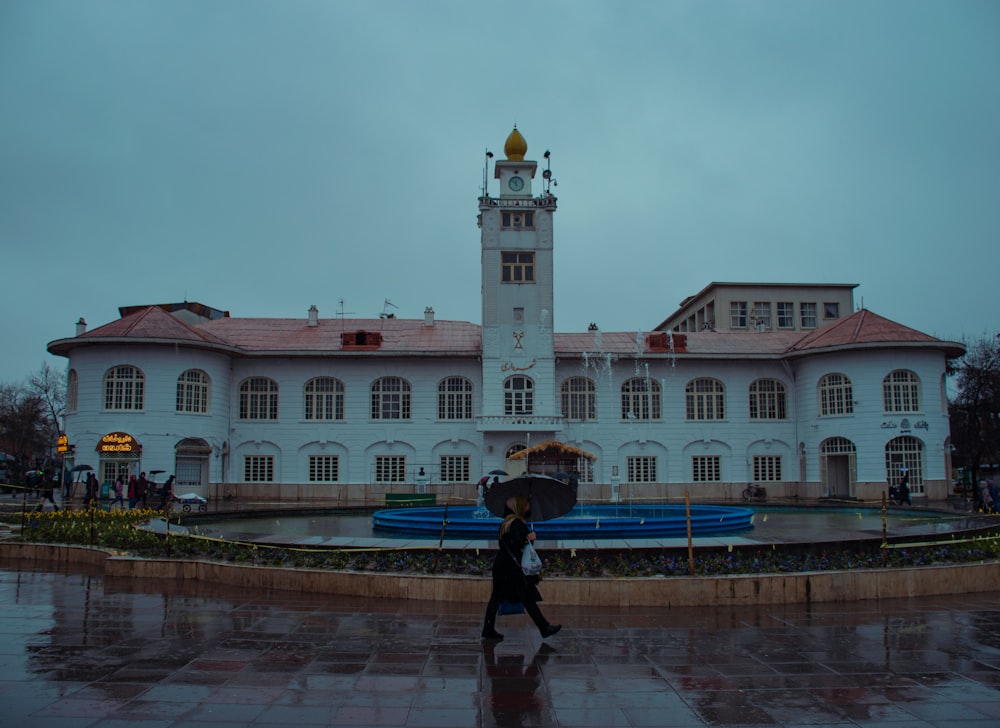 a woman holding an umbrella in front of a building