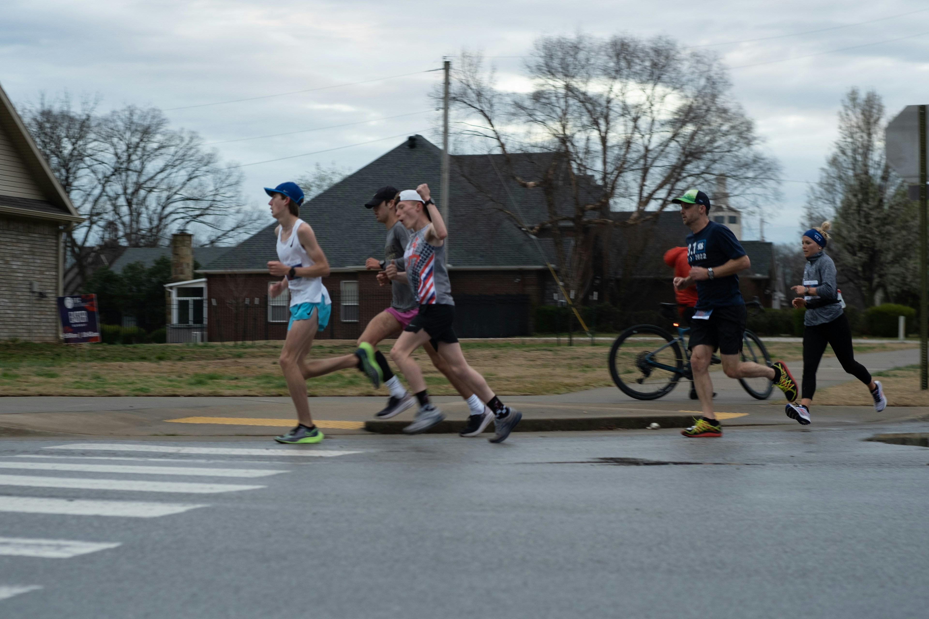 Runners cheering while rounding a corner in a marathon.