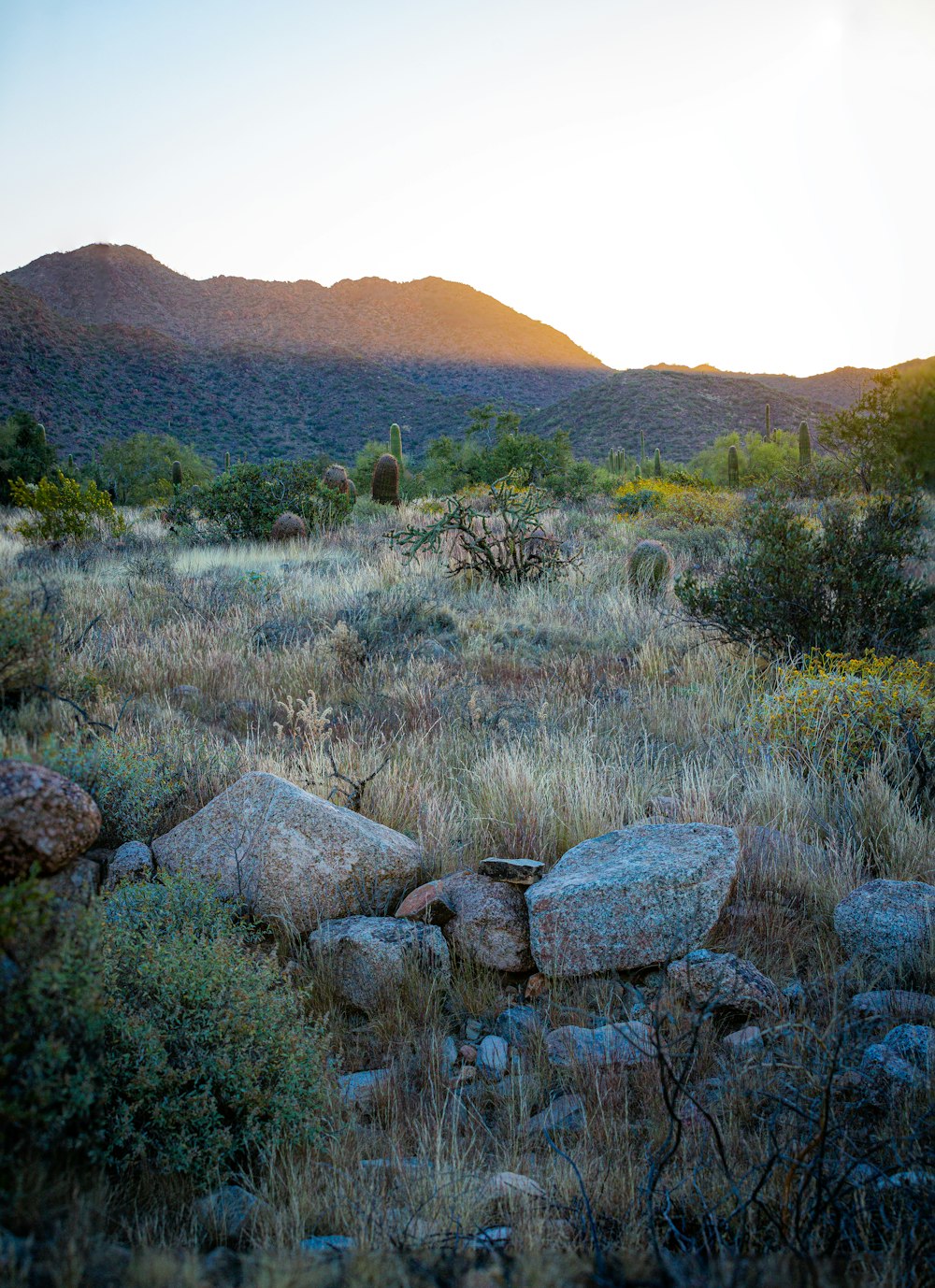 the sun is setting over the mountains in the desert