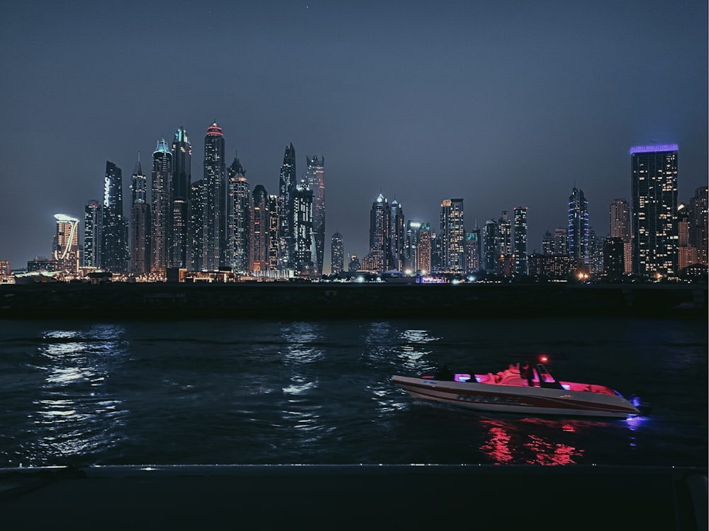 a boat is in the water near a city at night