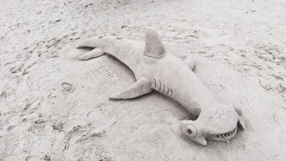 a sand sculpture of a shark on a beach