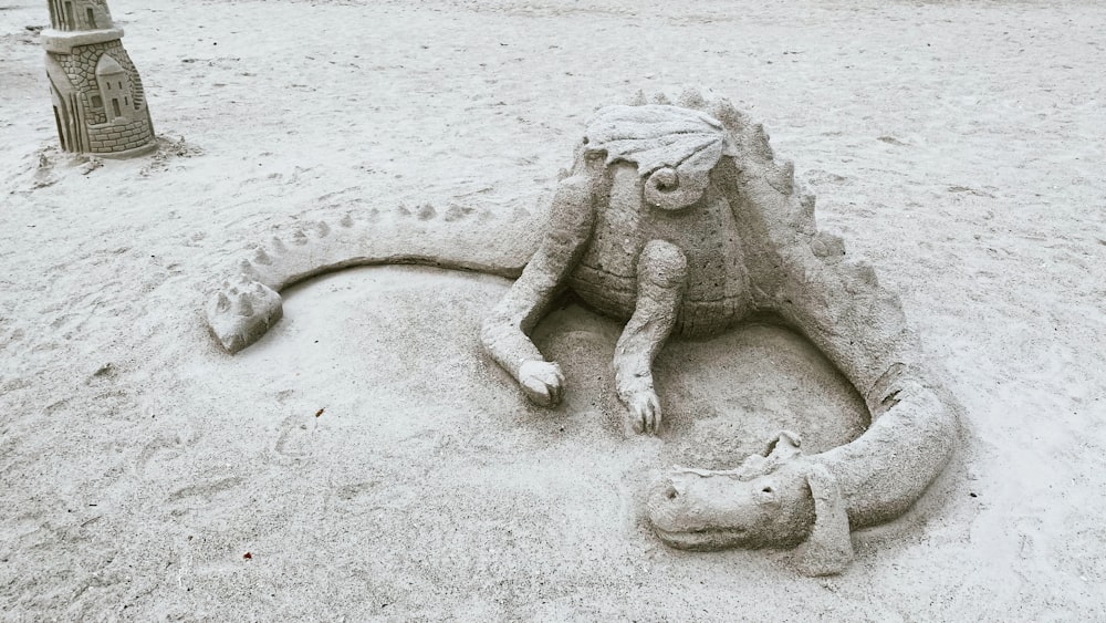a sand sculpture of a dragon and a cat