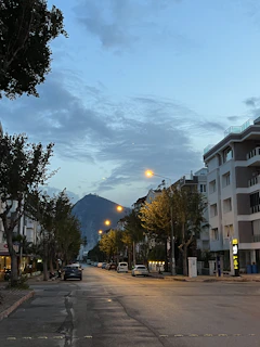 Streetlights illuminating the mountain road at dusk with a peaceful atmosphere