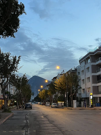 Streetlights illuminating the mountain road at dusk with a peaceful atmosphere