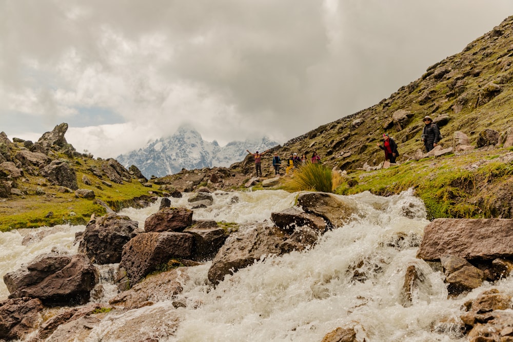 a group of people standing on top of a waterfall