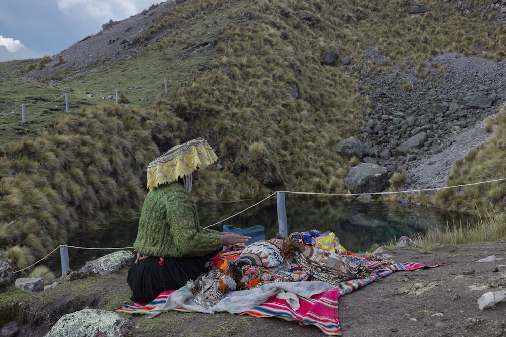 a person sitting on a hill with a blanket