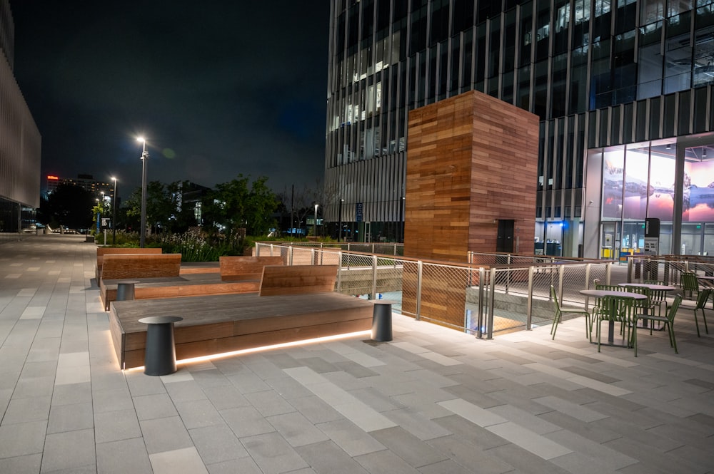 a wooden bench sitting in front of a tall building