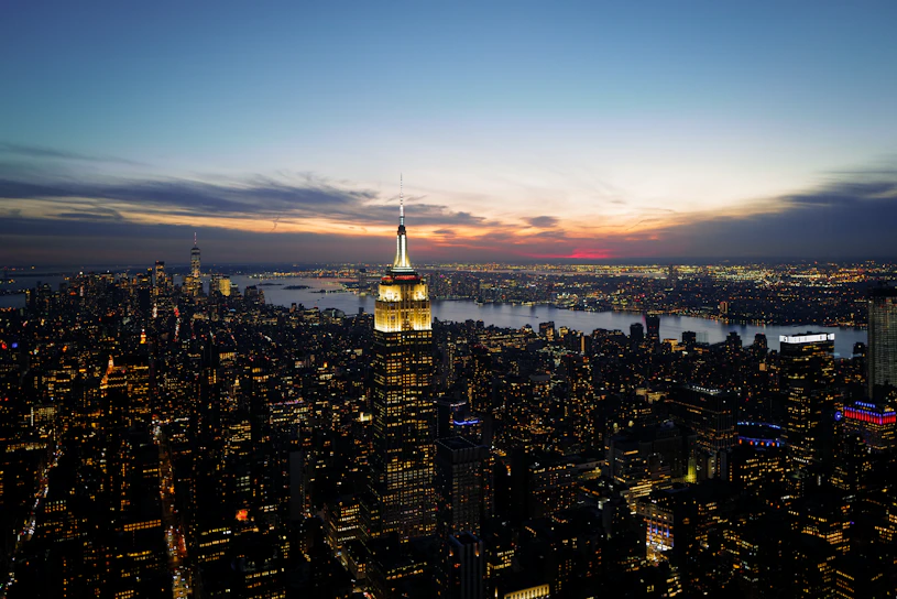 A panoramic view of a bustling city skyline at sunset, highlighting modern architecture and vibrant urban life.