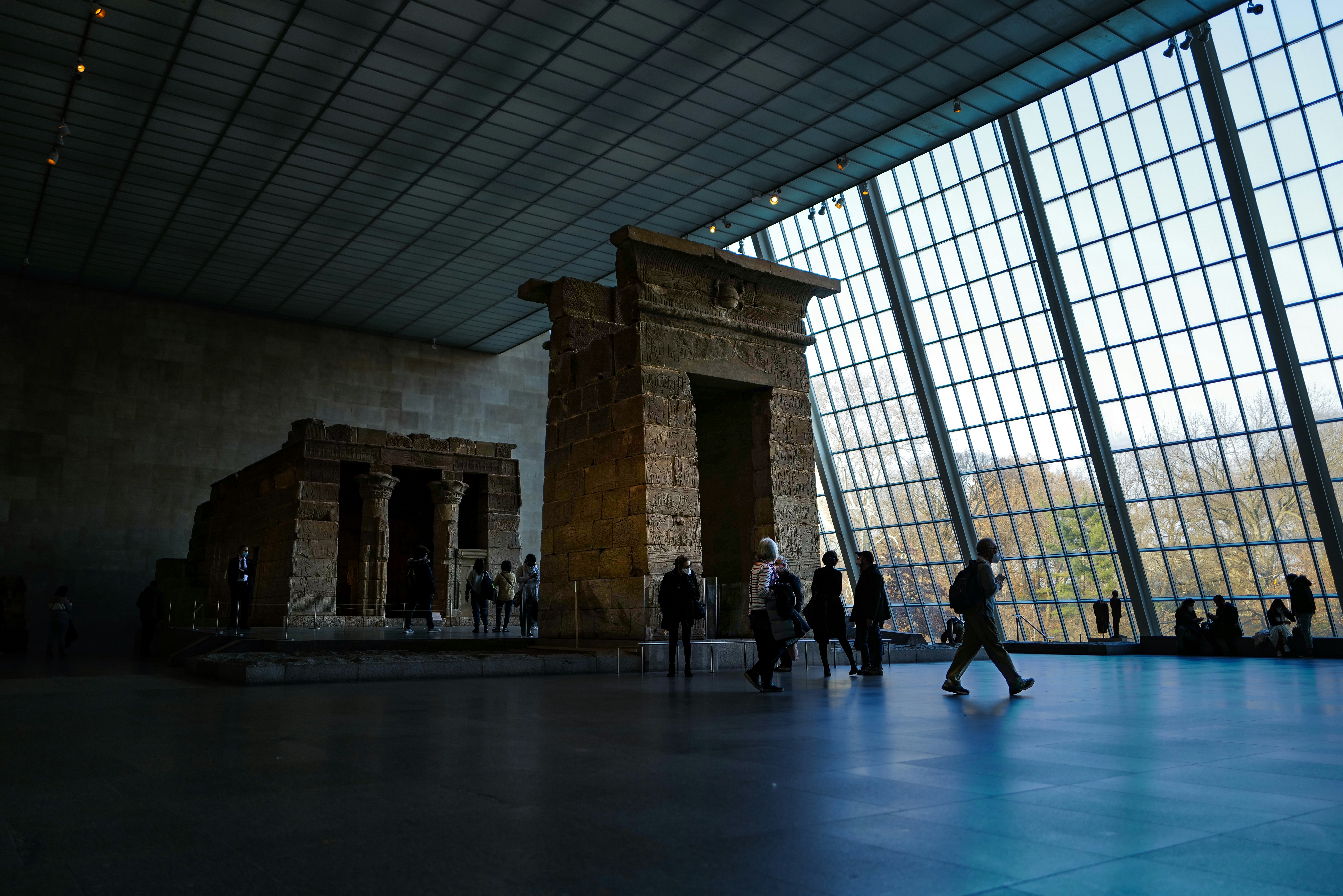 a group of people walking around a museum