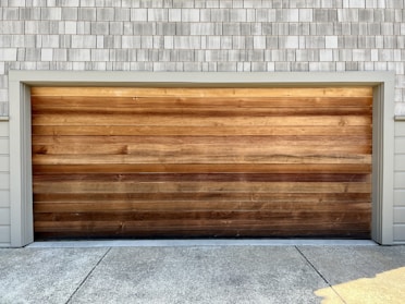 a wooden garage door on a brick building